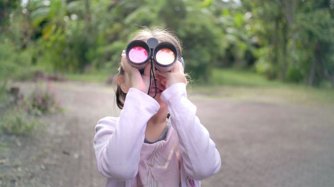 使用双筒望远镜的小女孩