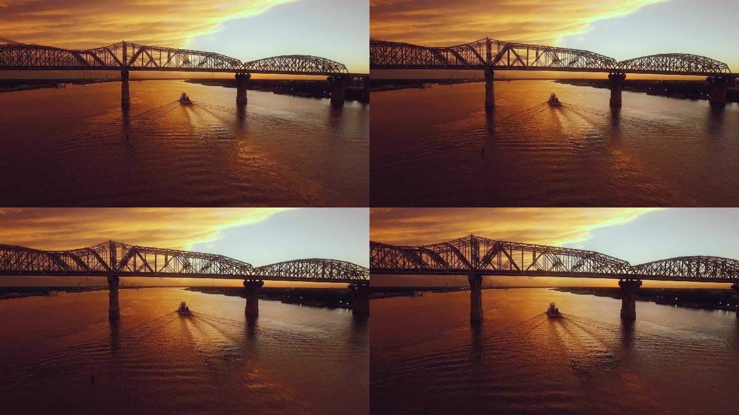 日落时，一艘船朝密西西比河上的一座桥驶过