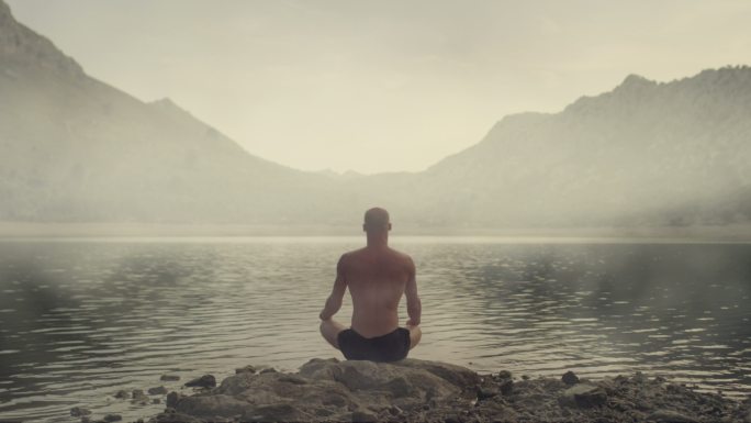 一个男人在湖边练习瑜伽
