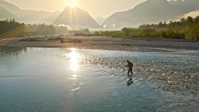 渔夫日出时在美丽的河流上钓鱼