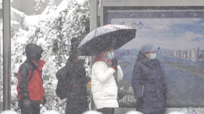 冰雪天气公交站等车的乘客