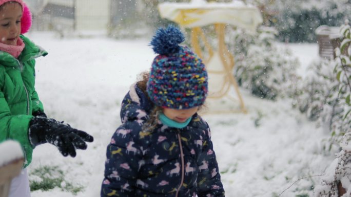 爸爸和他的孩子们在后院玩雪球