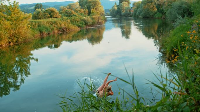 一位中年女性用秋千跳进河里