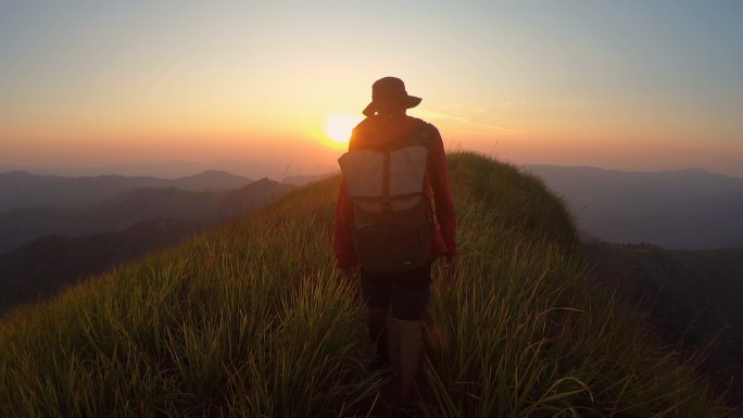 山脊上的男性冒险朝阳日出群山峻岭山岭