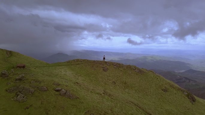 山上的徒步旅行者高峰巅峰高处操控无人机眺