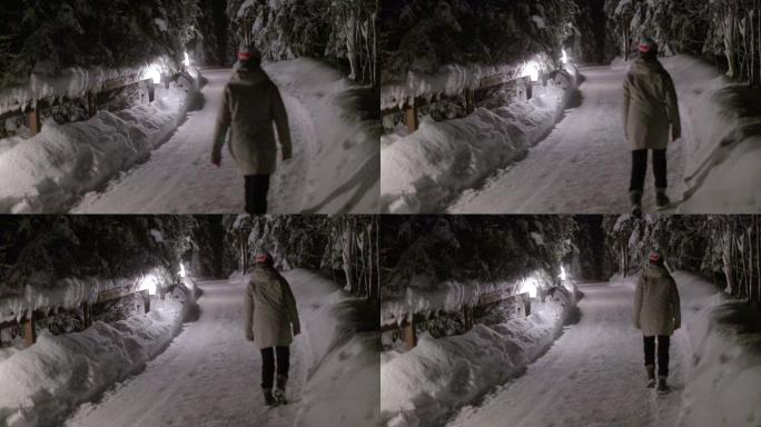 女性在夜晚享受雪。