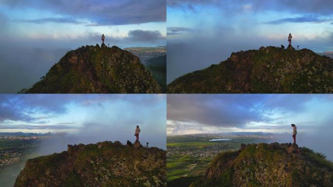 一个人站在险峻的山峰上观云海日出航拍素材