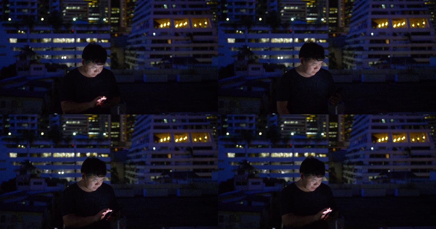 男人晚上在屋顶使用智能手机