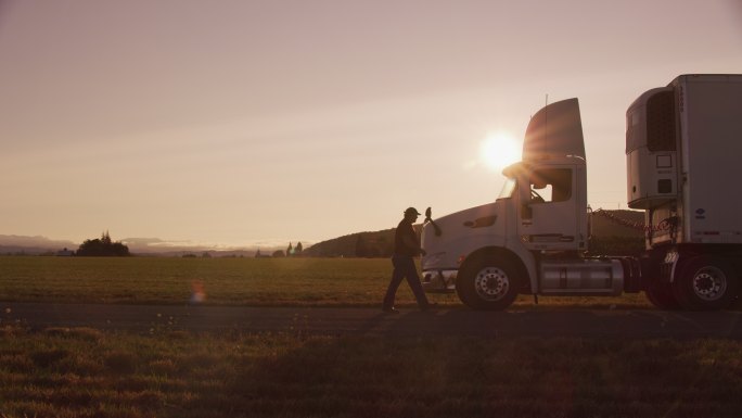 日落时分，卡车司机走向卡车。