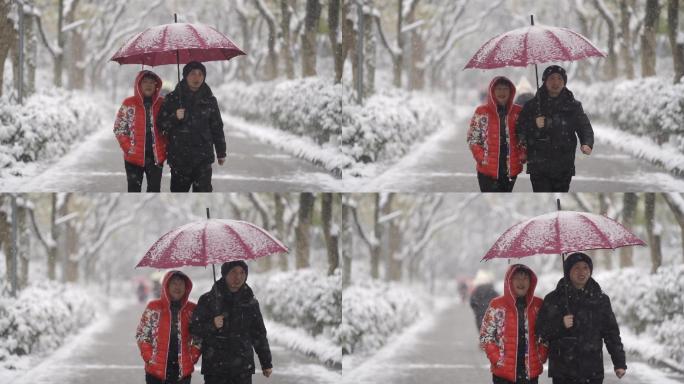 雪地里夫妻打伞有说有笑的走路