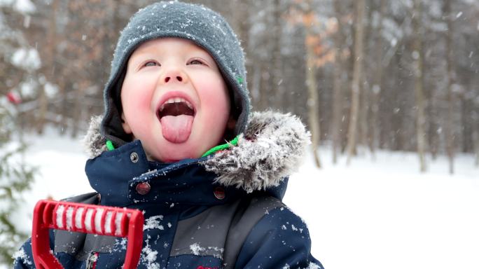 小男孩用舌头接住雪花