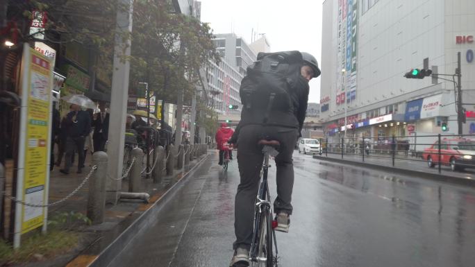 雨天在街道上骑自行车的男人