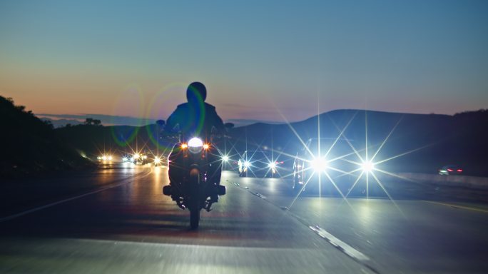 骑摩托车沿着高速公路行驶。
