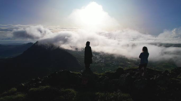 两人站立在险峻的山峰上观云海日出航拍素材