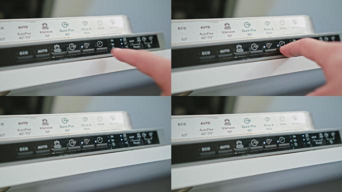 用手指按洗碗机上的开关按钮