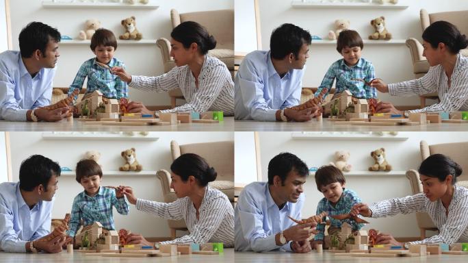 夫妇和小儿子在家里玩恐龙玩具