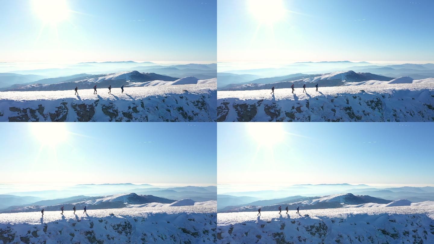 四人在一座雄伟的雪山上徒步旅行