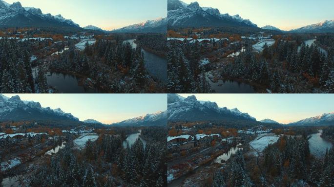 日落时俯瞰白雪覆盖的常青树、河流和山村