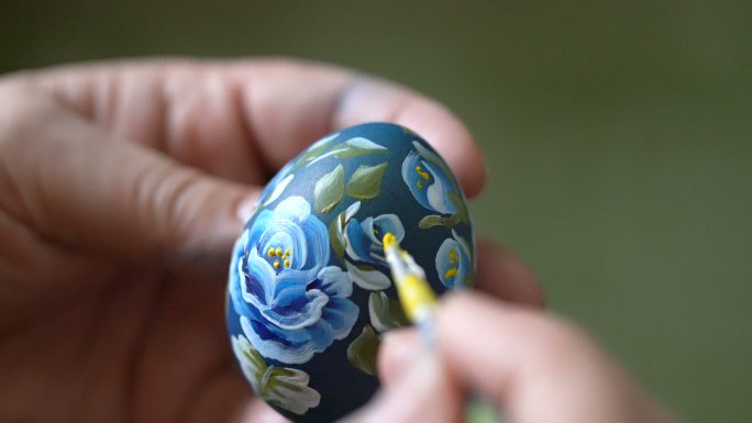 一个女人画复活节彩蛋的特写镜头。
