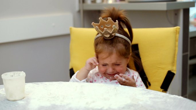 可爱的小女孩在桌子上玩面粉