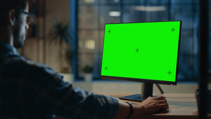 商人使用带有模拟绿色屏幕的台式电脑。