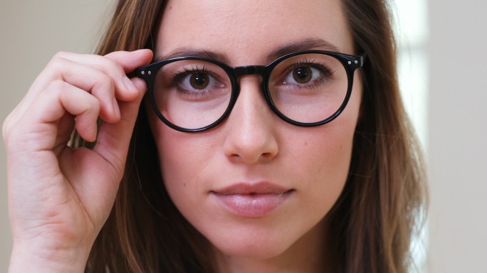 戴眼镜的女孩戴眼镜的动作自信照镜子