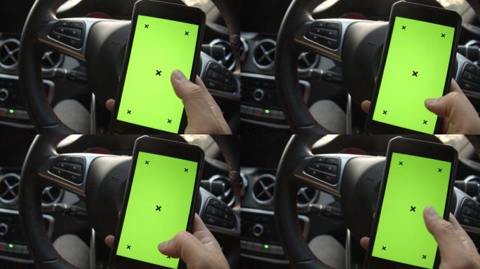 一名男子手持一部带有绿色屏幕的智能手机。