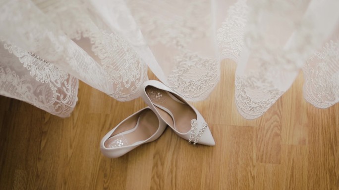 新娘的鞋子放在白色窗帘附近