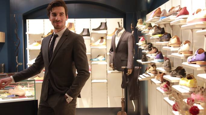 一位年轻男性企业家站在鞋店的肖像。