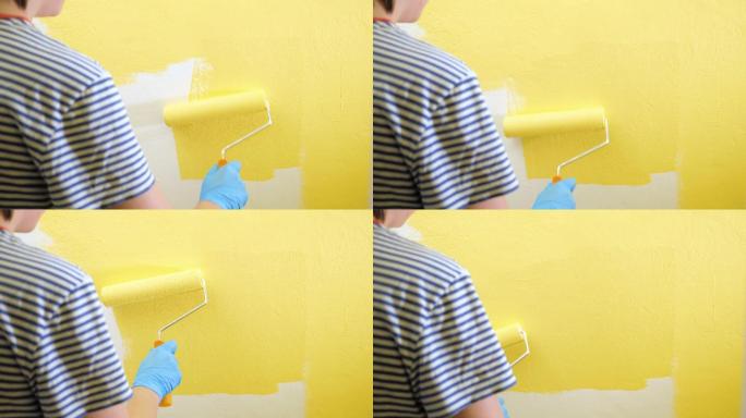 女孩用右手拿着滚筒把墙漆成黄色