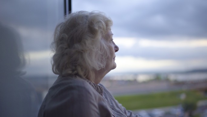 孤独的老妇人看着城市的风景