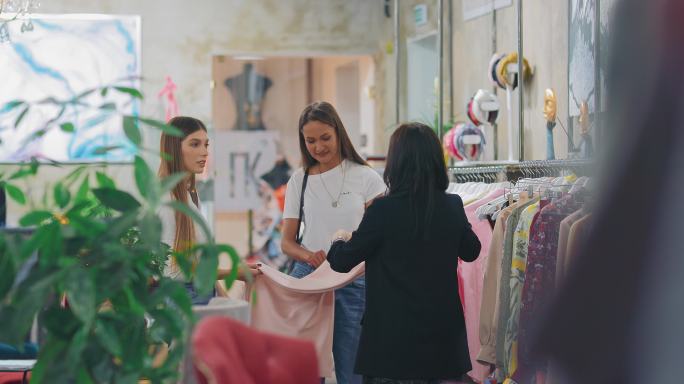 年轻女性在商店里挑选时髦的衣服。