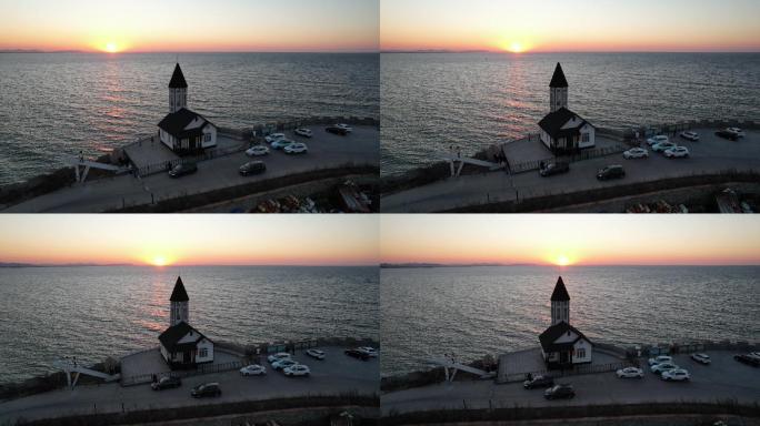 威海小石岛海洋观测站尖塔前的落日大海