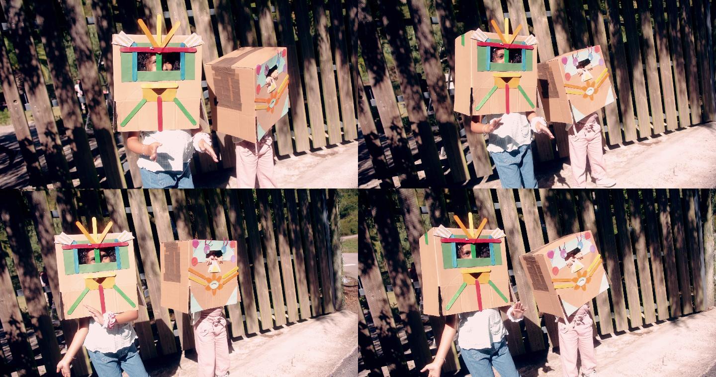 两个小女孩打扮成手工制作的纸板机器人