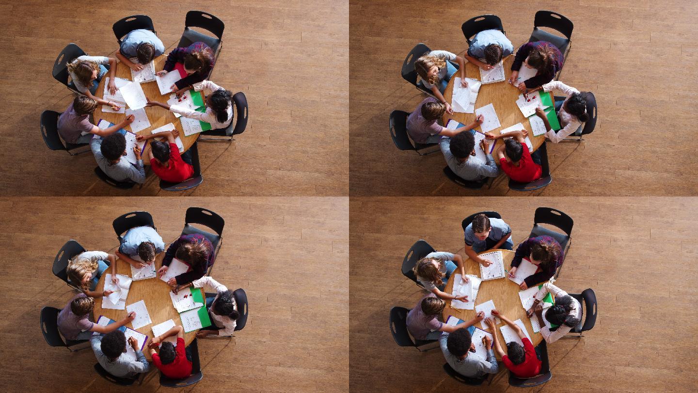 高中生围着桌子进行小组学习