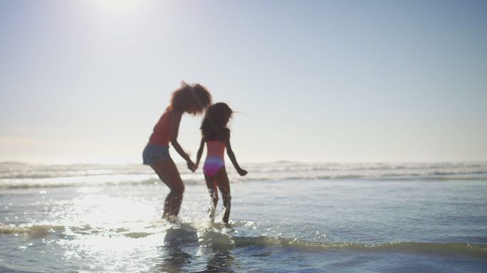一位母亲和她的小女儿在海滩