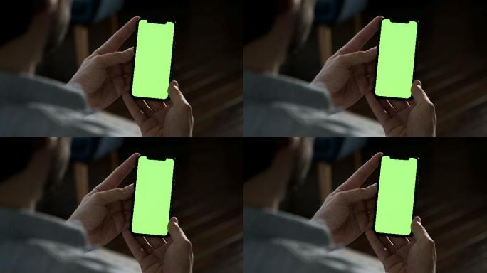 年轻人用智能手机绿屏绿幕抠图抠像后期绿布