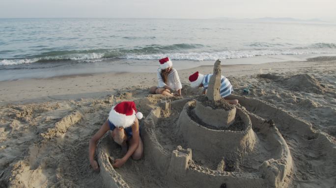 孩子们在夏季圣诞节建造沙滩城堡