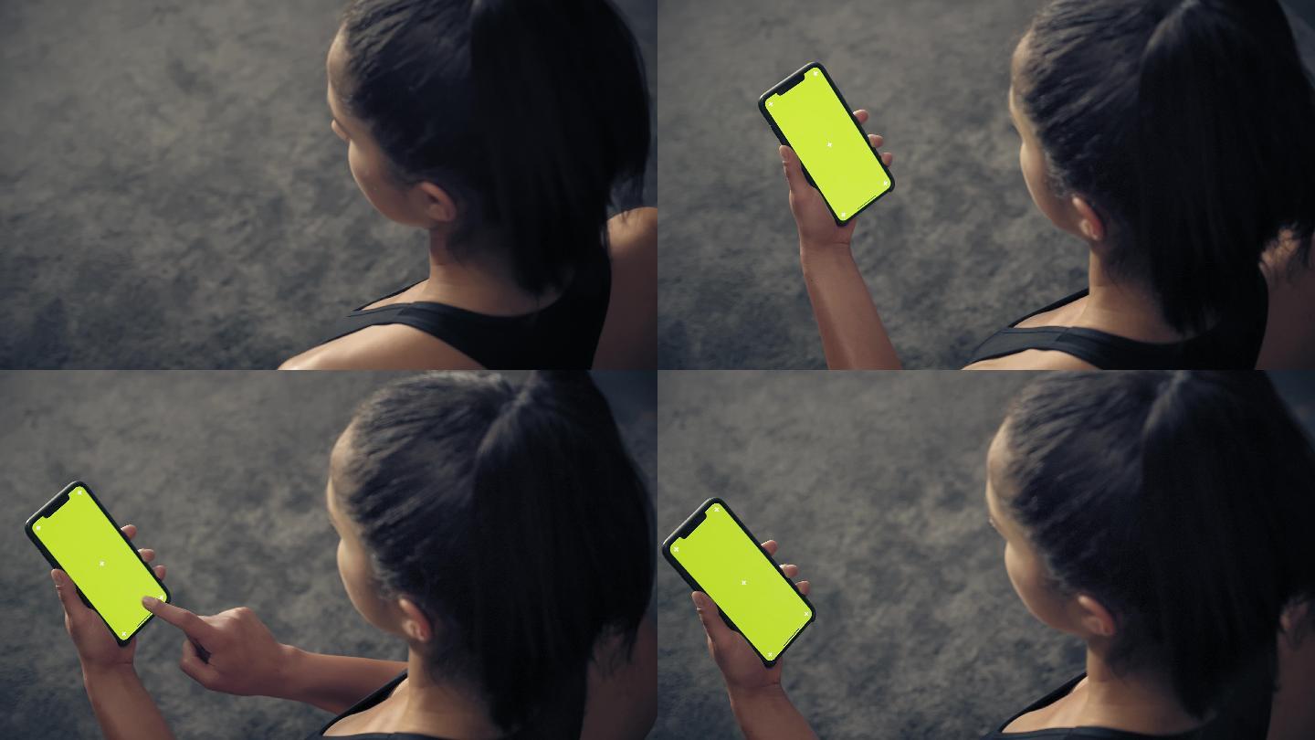 健身女性使用绿色屏幕智能手机的后视图