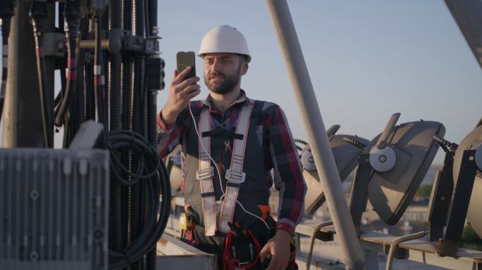 工程师在移动电话塔上进行视频通话