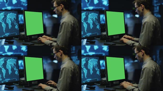 编程人员在系统控制室的绿屏计算机上工作。