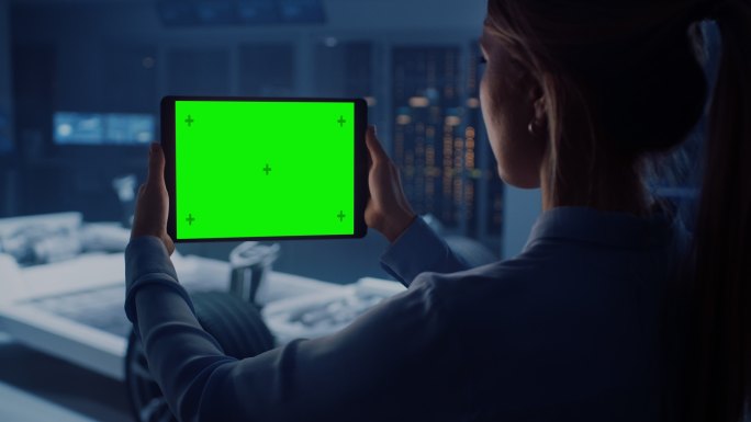 女工程师手持绿屏的平板电脑