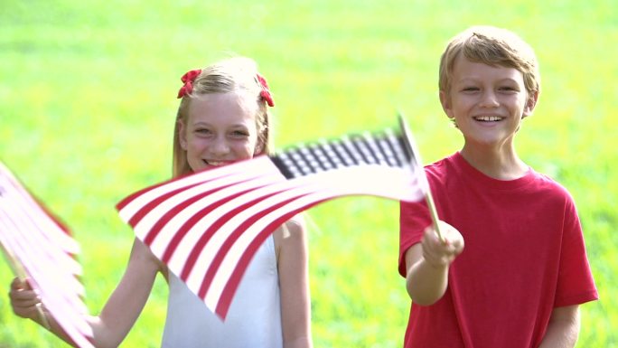 两个孩子挥舞着美国国旗
