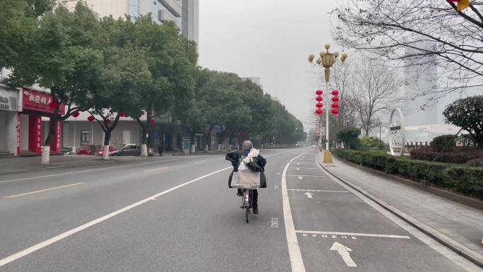 城市街头骑自行车的白发老人
