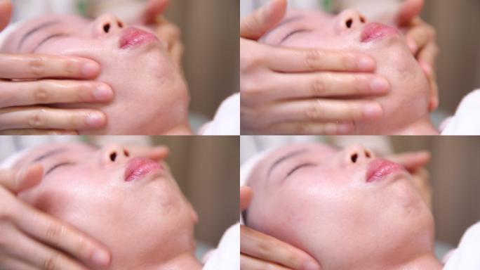 水疗养生俱乐部的迷人女性接受面部按摩