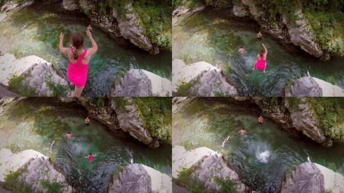 女孩从岩石上跳到河里的慢动作