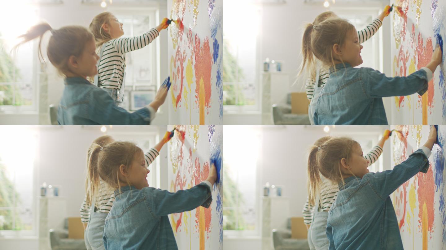 两个小女孩用手蘸着颜料在墙上画手印