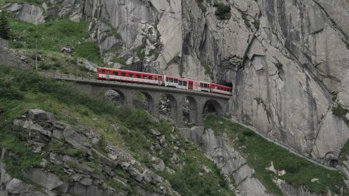 红色列车经过瑞士阿尔卑斯山的高架桥。