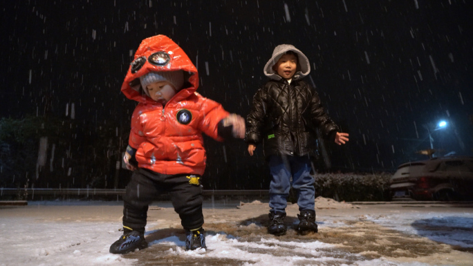 大雪夜晚孩子开心玩雪