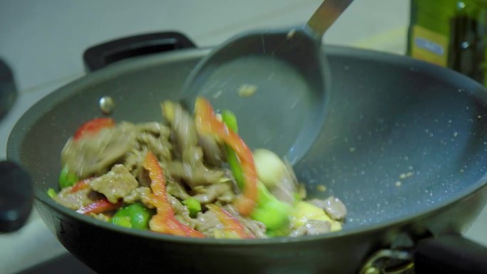 厨房忙碌炒菜：甜椒彩椒炒肉烹饪过程